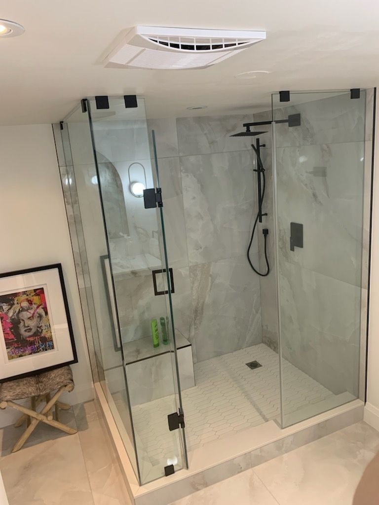 Marble bathroom with a glass walk-in shower and matte black fixtures